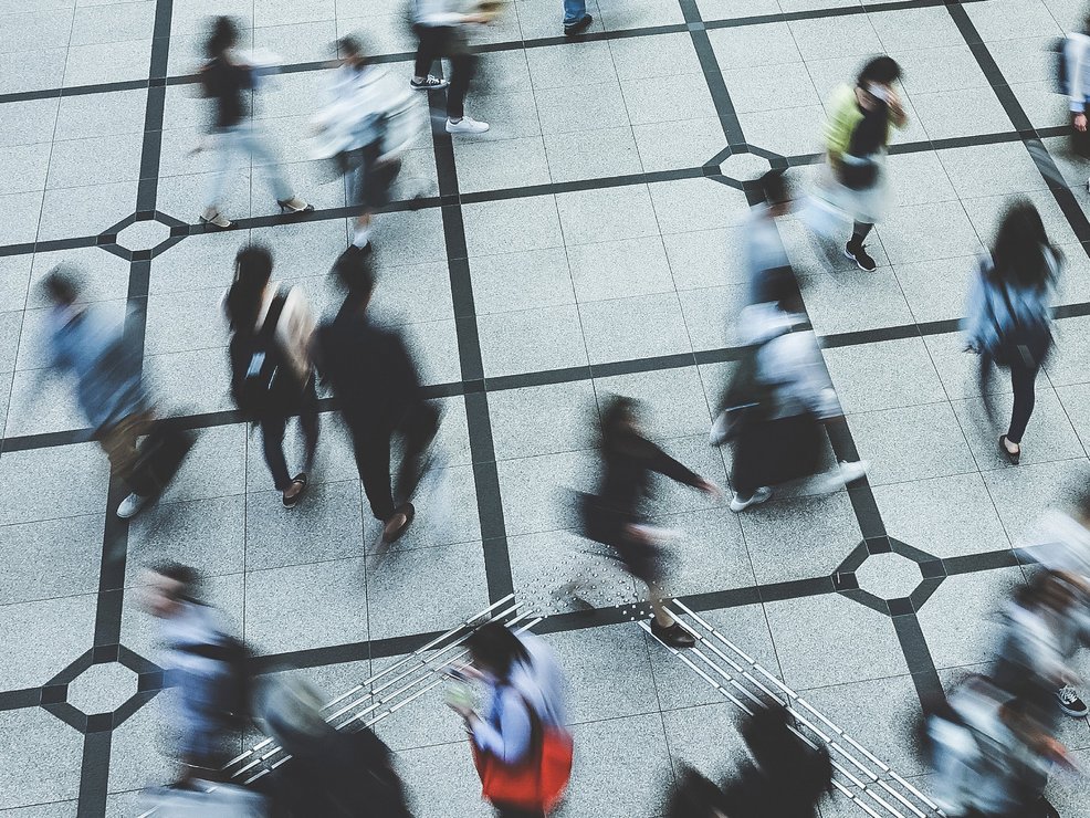 Verschwommene Menschenmenge läuft über einen Platz